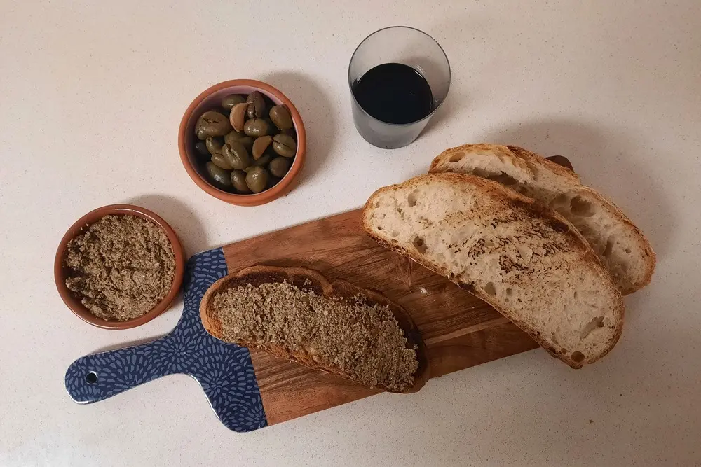 Tapenade de aceitunas casero con ajo asado y pan rústico