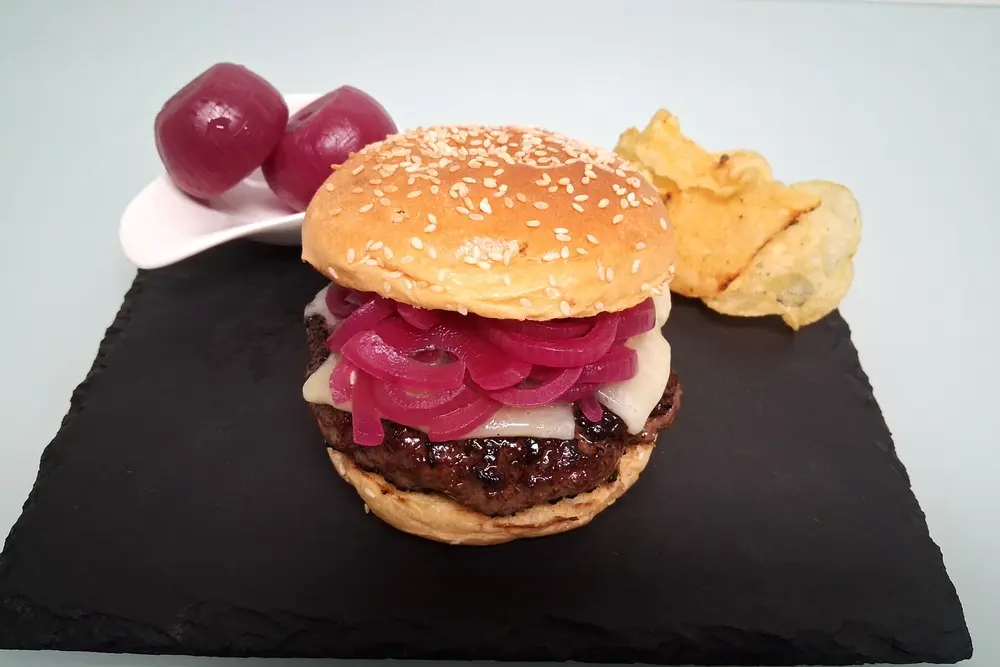Hamburguesa gourmet casera con cebolla en vinagre y queso curado